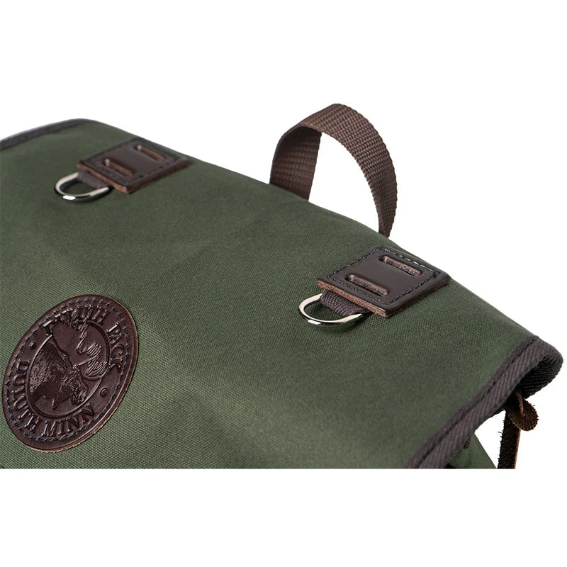 Outlander Pack in green canvas with leather accents, featuring a low-profile design ideal for rugged outdoor and bushcraft use by Duluth Pack.