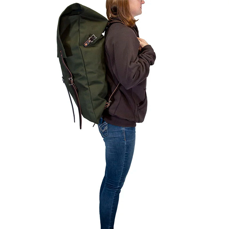 #2 Original Canoe Pack - 59 L in tough green canvas with leather straps, worn by a person hiking, showcasing durable outdoor gear by Duluth Pack.