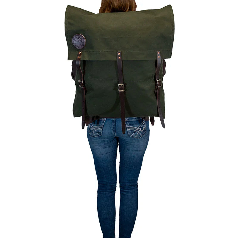 #2 Original Canoe Pack - 59 L in dark green canvas with reinforced leather straps, worn by a person standing, showcasing durable outdoor hiking gear by Duluth Pack.