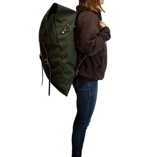 #3 Original Pack - 72 L in tough green canvas with rugged leather straps worn by a person outdoors, showcasing durable handmade craftsmanship by Duluth Pack.