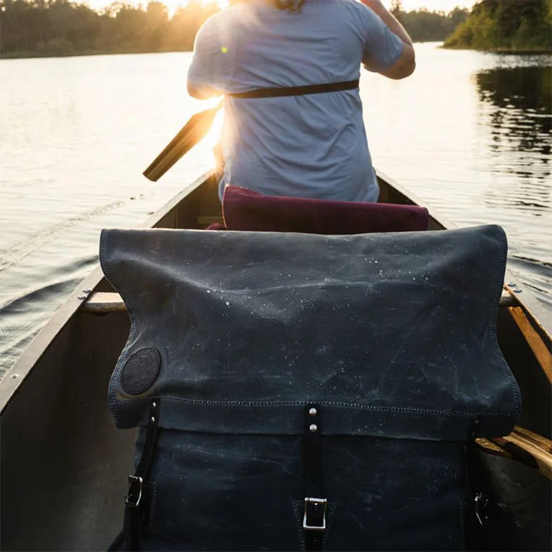 #3-70 Utility Pack - 60 L in rugged waxed canvas, shown on a canoe during an outdoor adventure at sunset, highlighting durable craftsmanship from Duluth Pack.