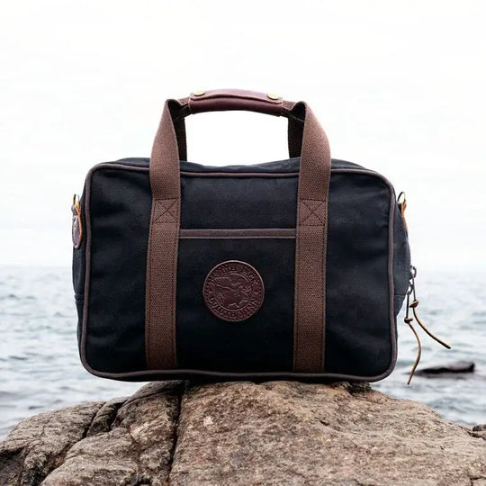 Safari Briefcase In Black Sitting On A Rock In front Of A Foggy Lake