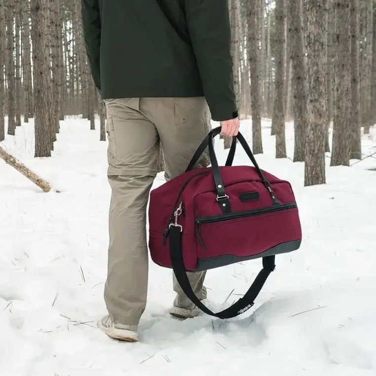 NEW Limited Edition Lake Huron Weekender Duffel Being Carried Through A Snowy Forrest By A Man
