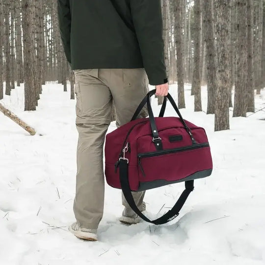 NEW Limited Edition Lake Huron Weekender Duffel Being Carried Through A Snowy Forrest By A Man