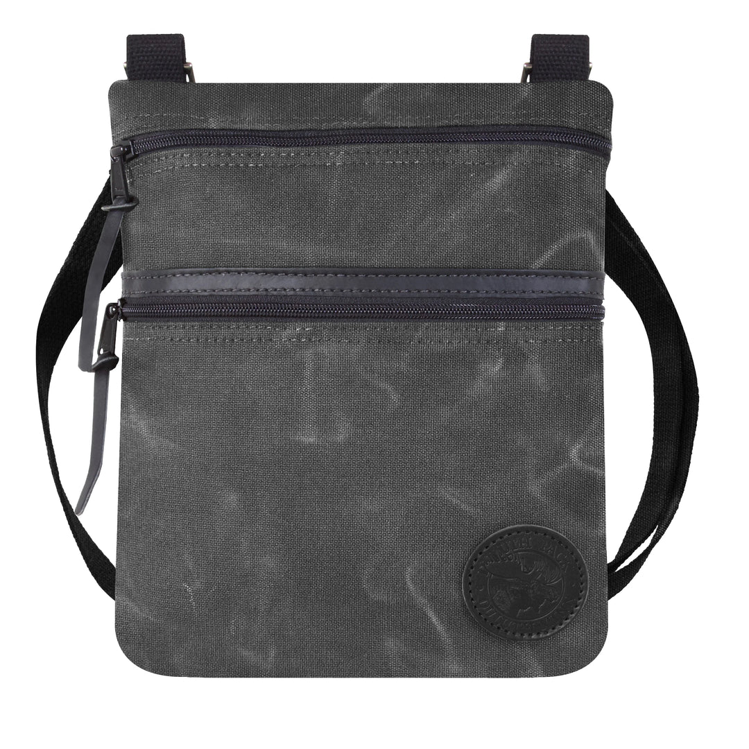 Traverse Crossbody Bag in waxed grey canvas with black adjustable cotton webbing strap, showcasing durable craftsmanship by Duluth Pack for outdoor use.