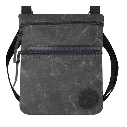 Traverse Crossbody Bag in waxed grey canvas with black adjustable cotton webbing strap, showcasing durable craftsmanship by Duluth Pack for outdoor use.