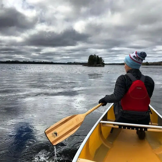 Bending Branches Arrow Paddle Being used by a woman on a canoe in a lake