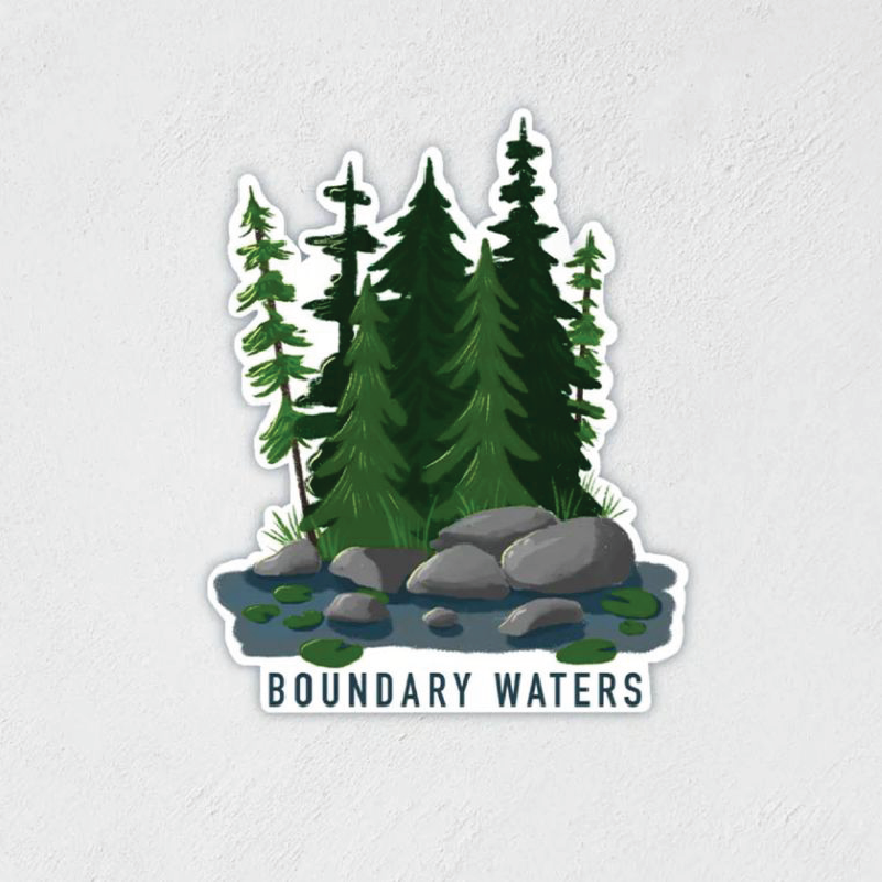 Sticker of some trees, rocks and water that says "BOUNDARY WATERS" at the bottom
