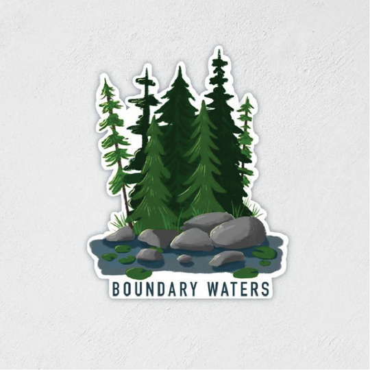 Sticker of some trees, rocks and water that says "BOUNDARY WATERS" at the bottom