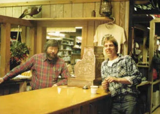 Photo: Two men in the Duluth Pack factory smiling. 