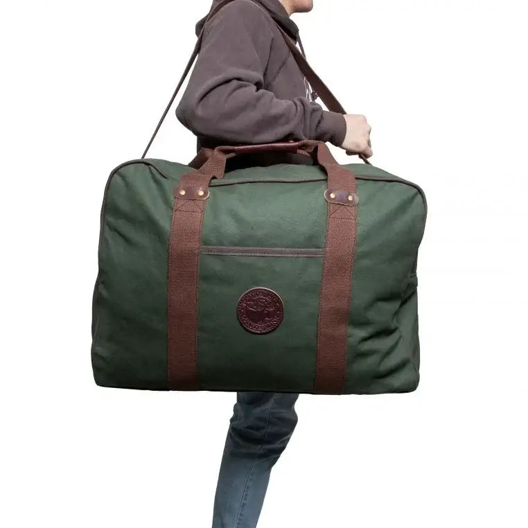 Medium Safari Duffel In Olive Drab Green Being Carried By A Man On A White Background