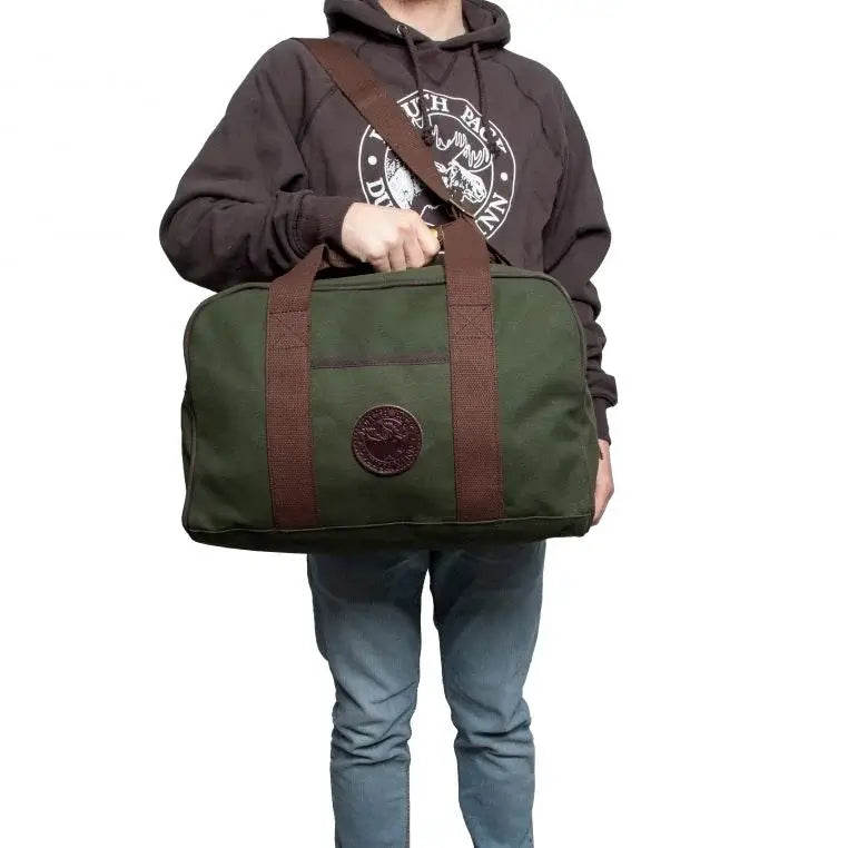 Small Safari Duffel In Olive Drab Green Being Held By A Man On A White Background